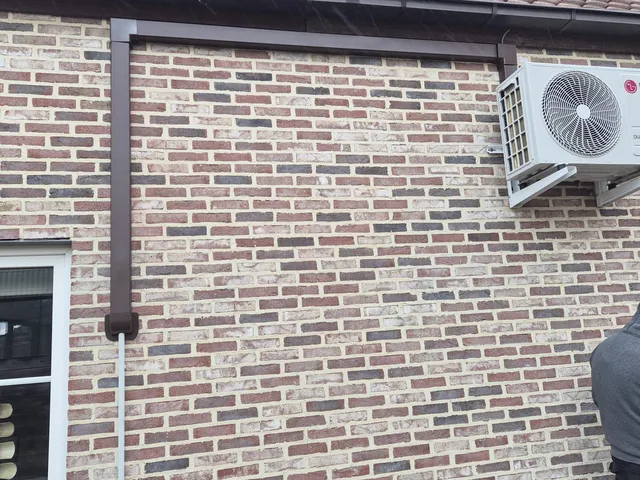 LG buitenunit hoog aan de gevel met bruine leidinggoot, Mol